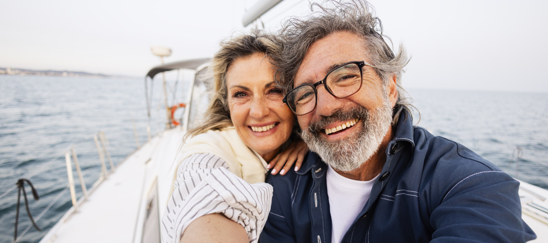 Happy senior couple sailing on yacht, embracing travel and adventure.