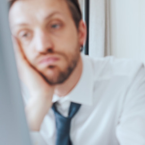 Photo of workers at desk looking depressed