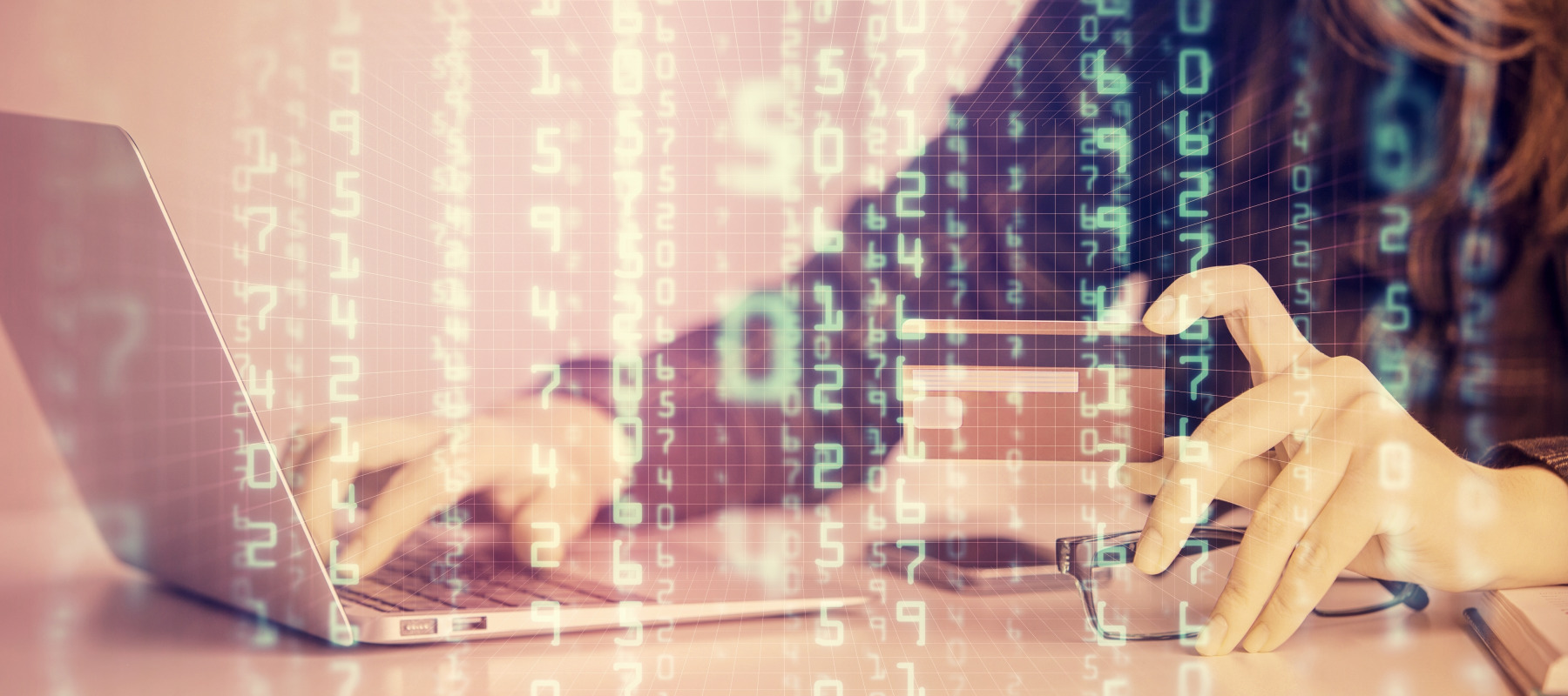 A woman works on a laptop with her credit card in hand while binary code is overlayed on top.