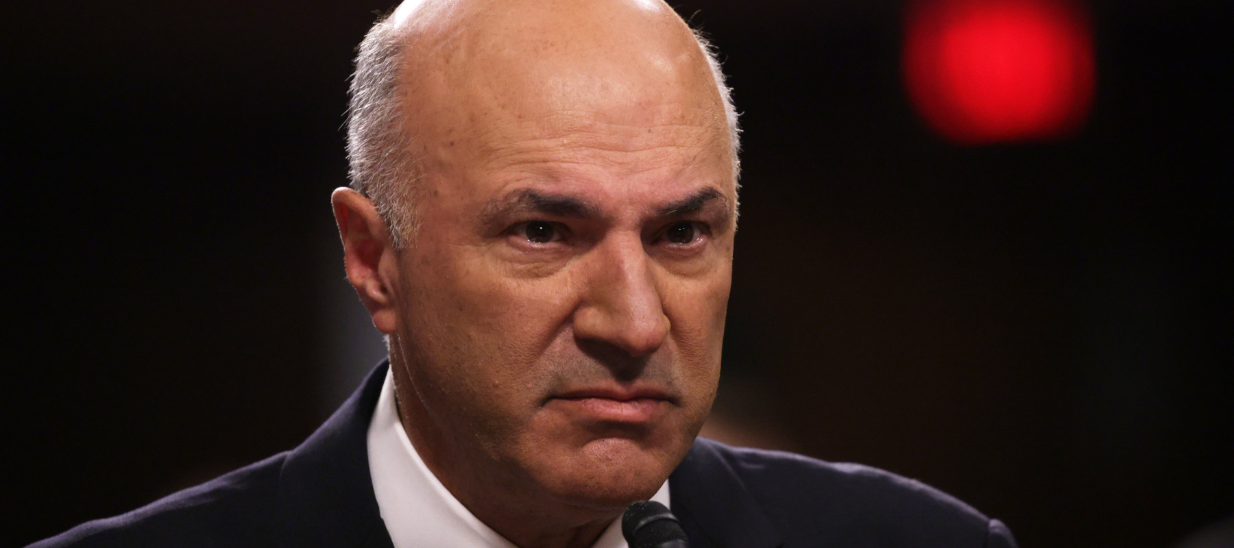 Investor and television personality Kevin O’Leary testifies during a hearing, looking very angry.