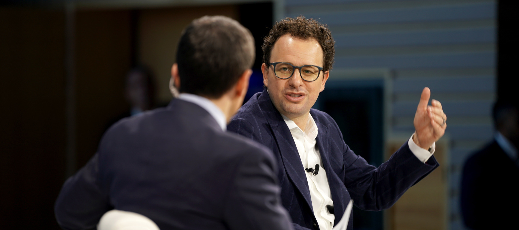 Andrew Ross Sorkin and Dario Amodei speak onstage. Amodei is gesturing.