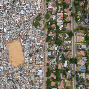 An aerial view of lower-income housing, spaced closely together, alongside wealthier homes with plenty of living space.