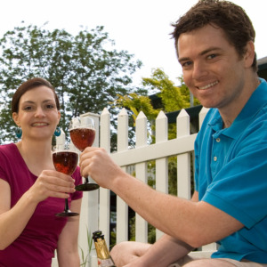 Photo of a couple outside clinking wine glasses