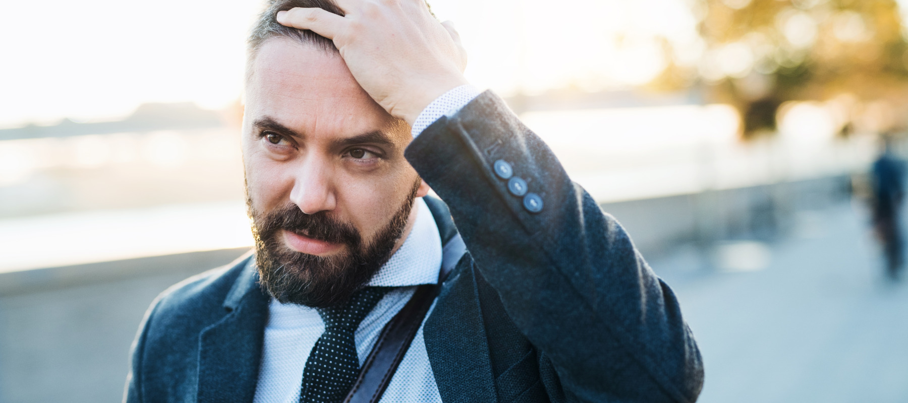 Exasperated man in suit walking down the street