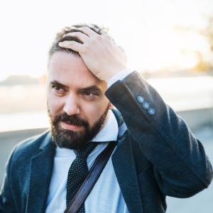 Exasperated man in suit walking down the street