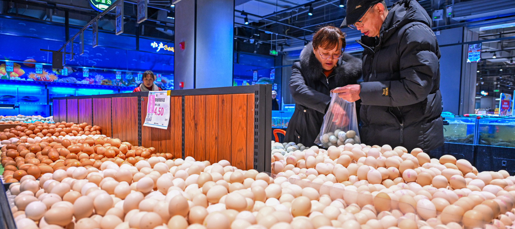 A couple sorts through eggs at a grocery store in China.