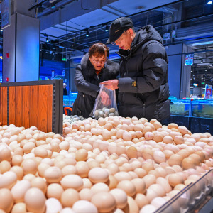 A couple sorts through eggs at a grocery store in China.
