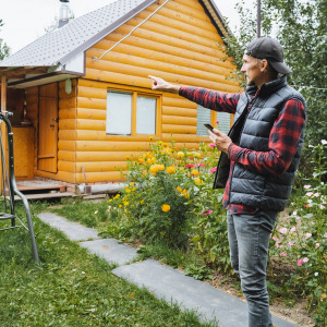 A man points toward a small cottage property.