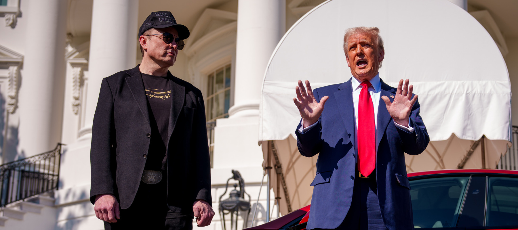 U.S. President Donald Trump, accompanied by Tesla and SpaceX CEO Elon Musk, speaks next to a Tesla Model S on the South Lawn of the White House.