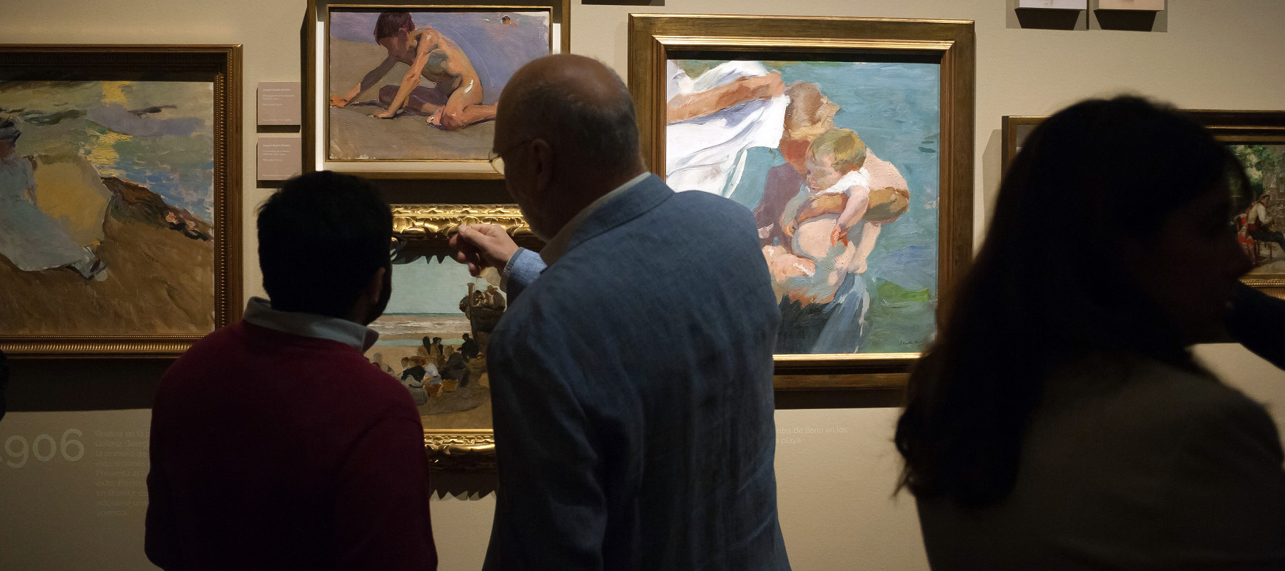 A photo of people looking at artwork by Joaquin Sorolla during an exhibition
