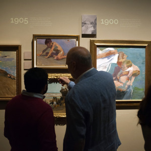 A photo of people looking at artwork by Joaquin Sorolla during an exhibition
