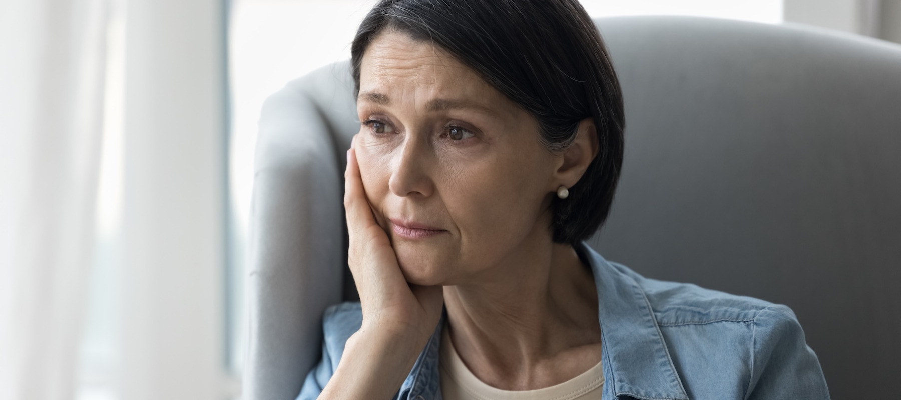 Upset woman sitting on a couch.