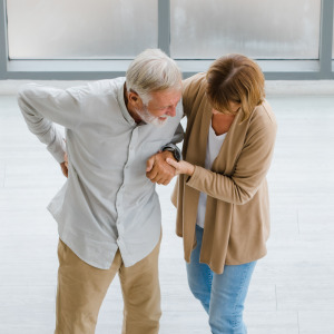Wife helps elderly husband recovering from a stroke.