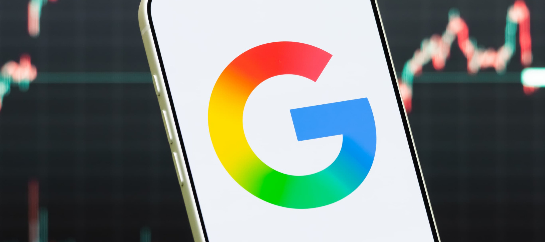 A photo of the Google logo in front of a stock chart