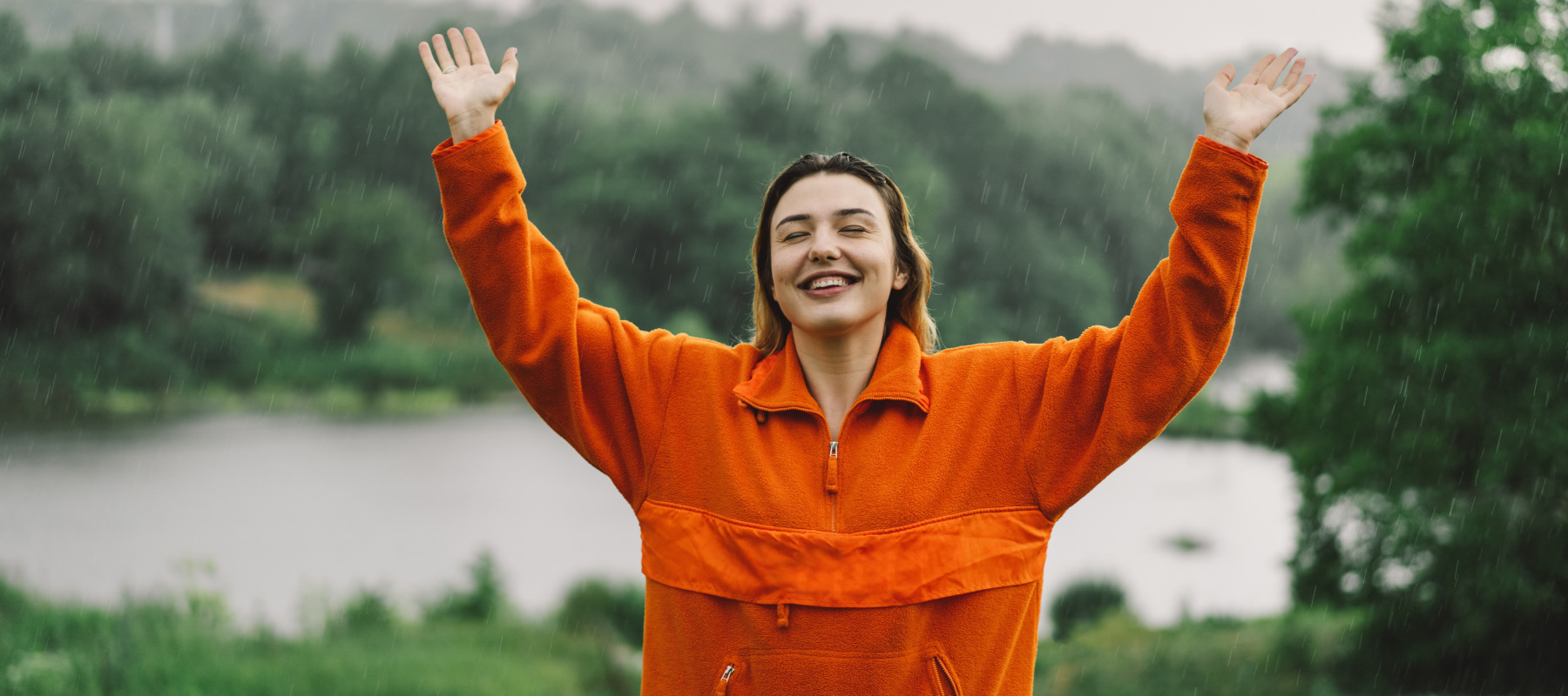 Young woman smiling with relief in the rain