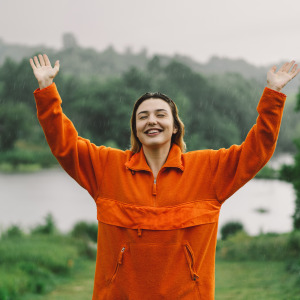 Young woman smiling with relief in the rain