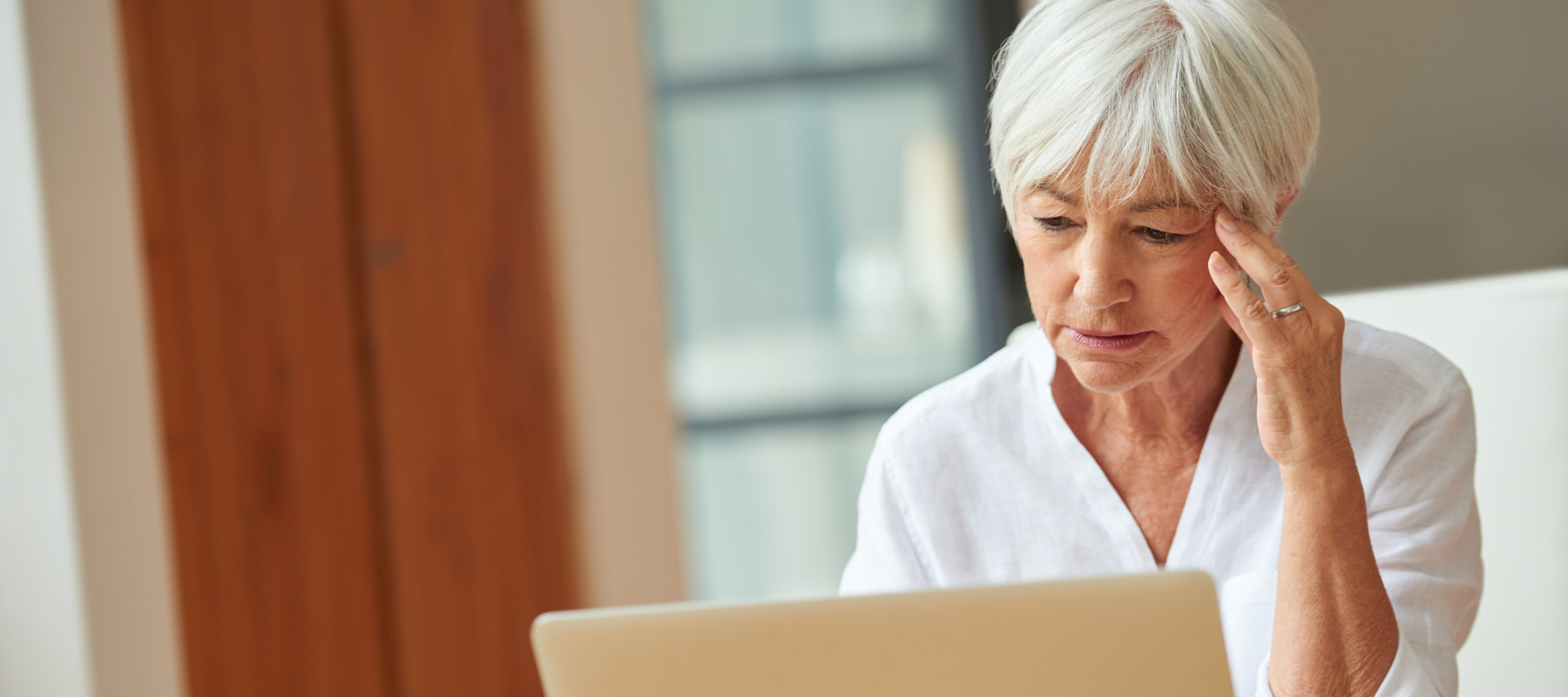 Elderly woman stressed about her finances.