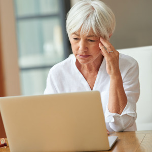 Elderly woman stressed about her finances.