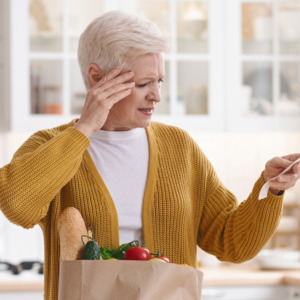 Photo of an older woman looking at her grocery bill