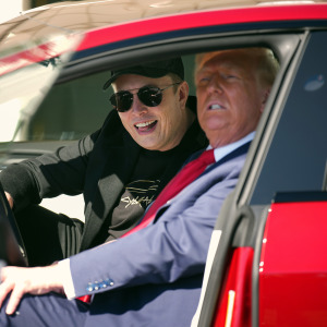 Elon Musk and President Trump sit inside a Tesla vehicle.