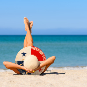 Woman on a beach with a hat with design inspiration from the Panama flag