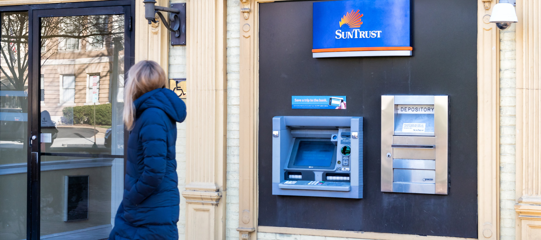 Woman walking past Suntrust ATM