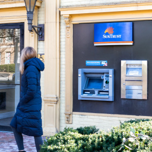 Woman walking past Suntrust ATM