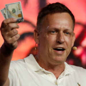 Peter Thiel, co-founder of PayPal, Palantir Technologies and Founders Fund, holds hundred dollar bills as he speaks during the Bitcoin 2022 Conference at Miami Beach Convention Center.