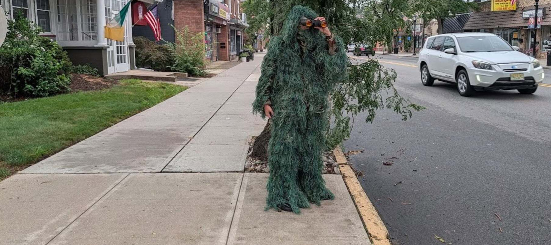 An officer is disguised as a shrub to catch distracted drivers on their cell phones.