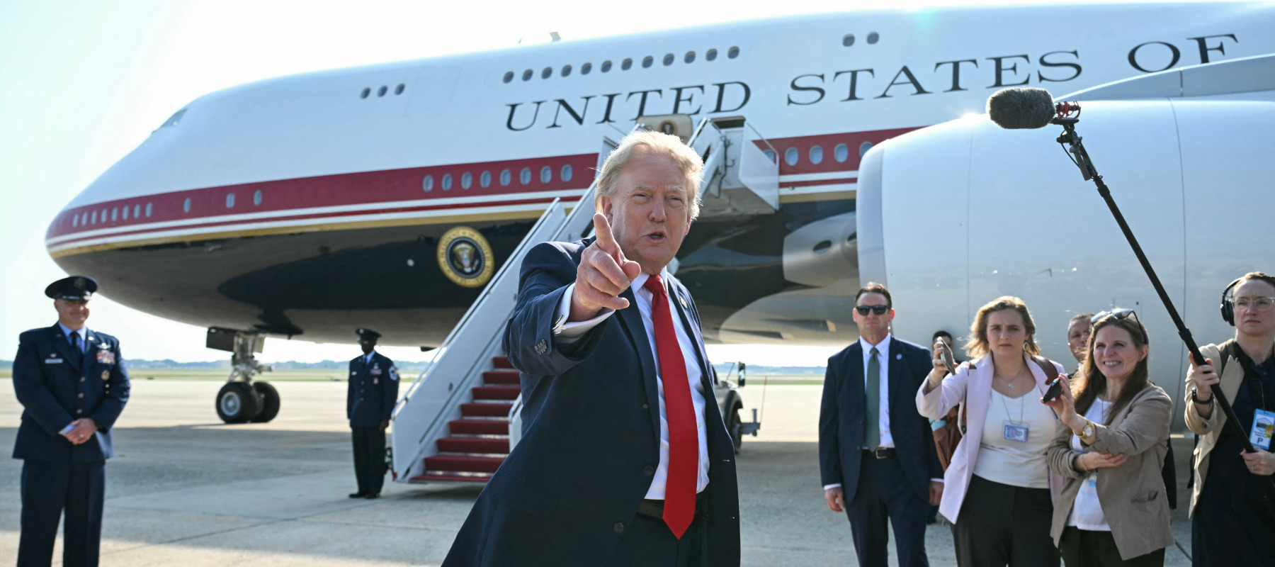 Trump gestures toward the media while standing in front of Air Force One.