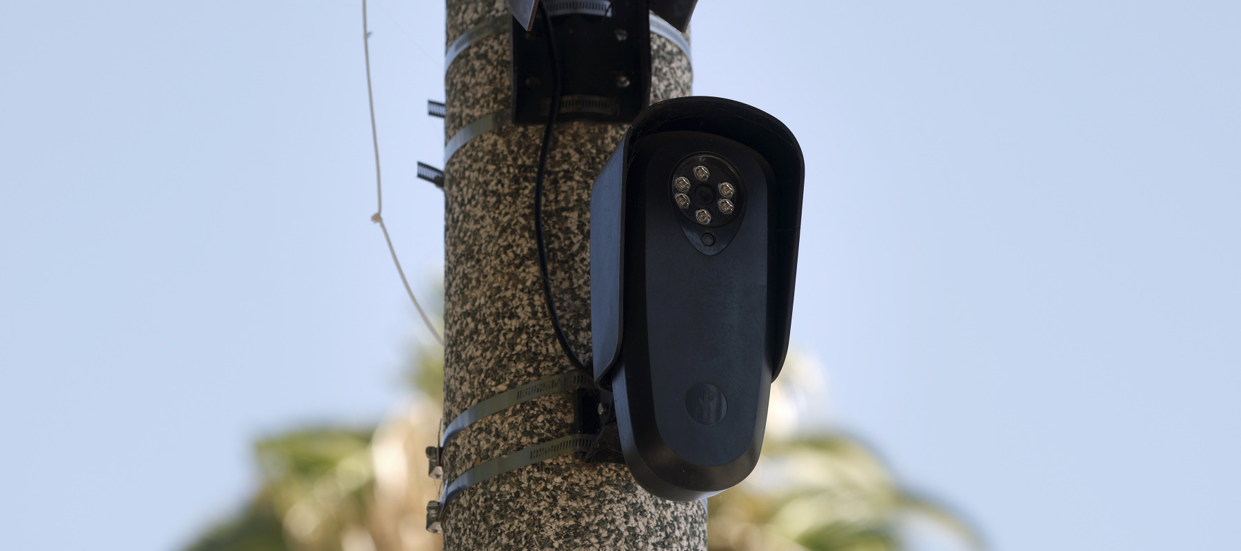 A Flock Safety camera is shown mounted to a light pole. The technology has drawn criticism from privacy advocates.