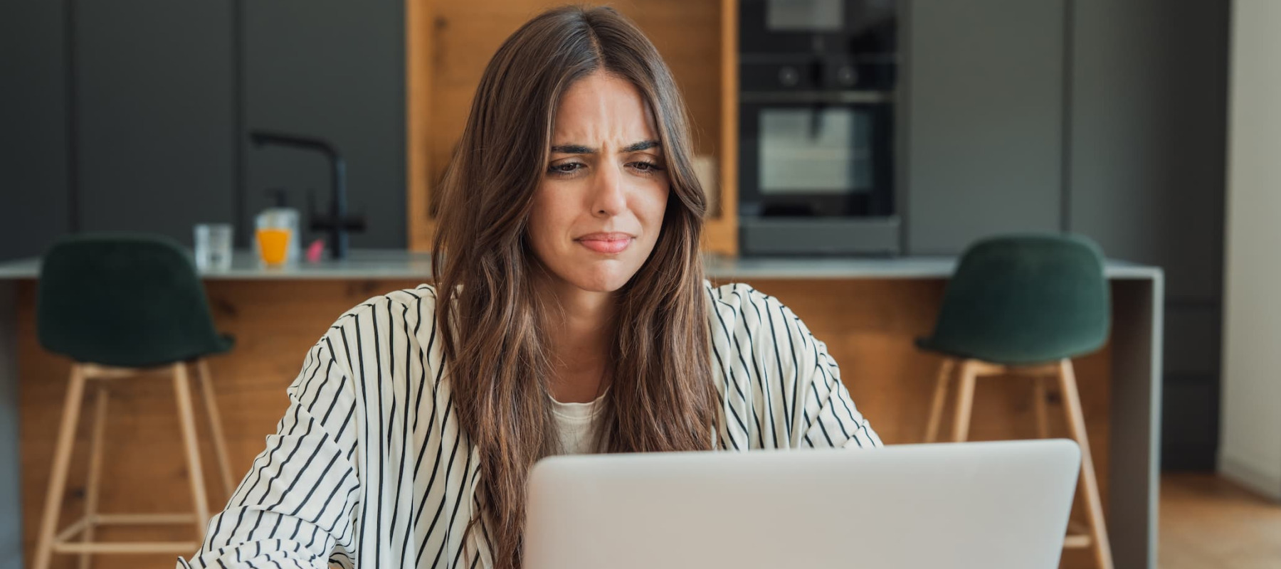 A photo of a woman confused on her laptop
