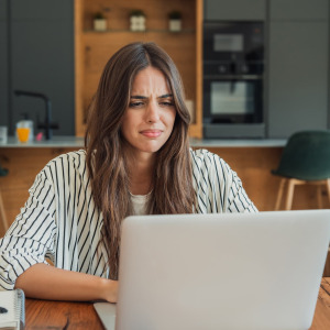 A photo of a woman confused on her laptop