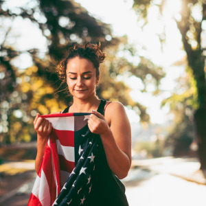 A photo of a millennial looking at an American flag