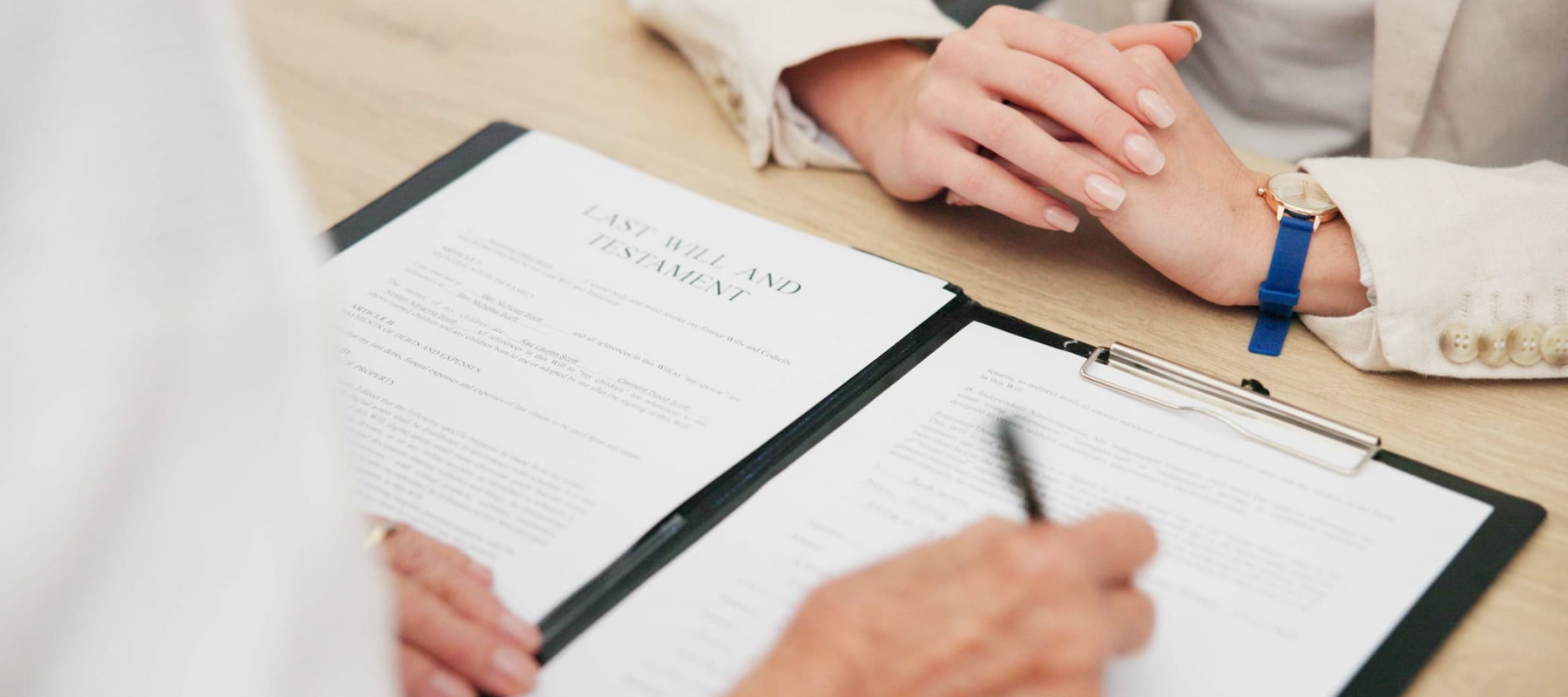 A photo of a woman signing a will