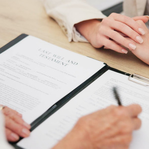 A photo of a woman signing a will