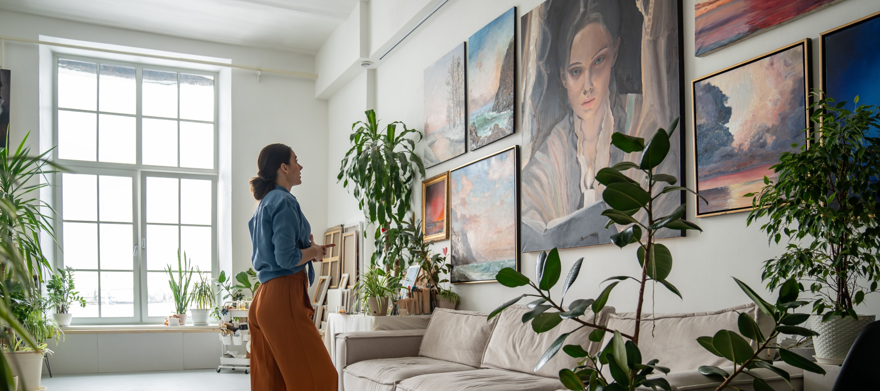 Woman looks at a portrait painting in her parents home.
