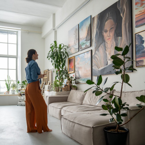 Woman looks at a portrait painting in her parents home.