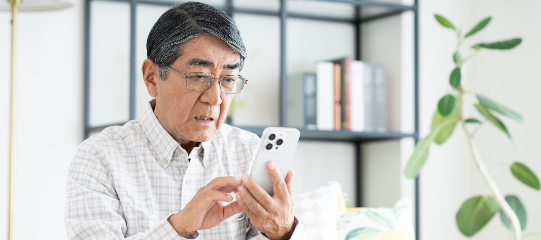 Concerned retiree looking at his phone.