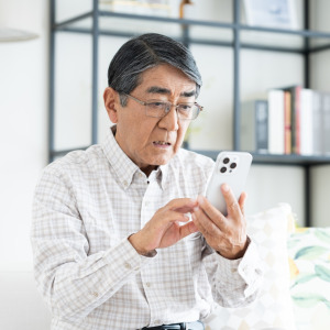 Concerned retiree looking at his phone.