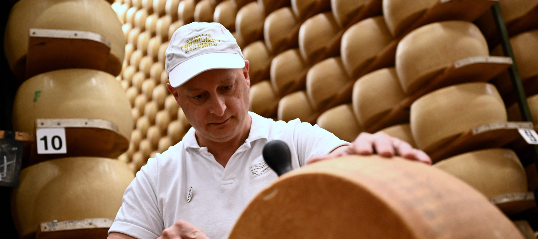 A worker cuts a wheel of Parmigiano Reggiano cheese at the Casearia Castelli.