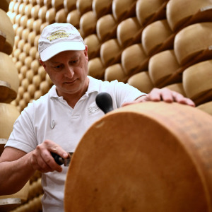 A worker cuts a wheel of Parmigiano Reggiano cheese at the Casearia Castelli.