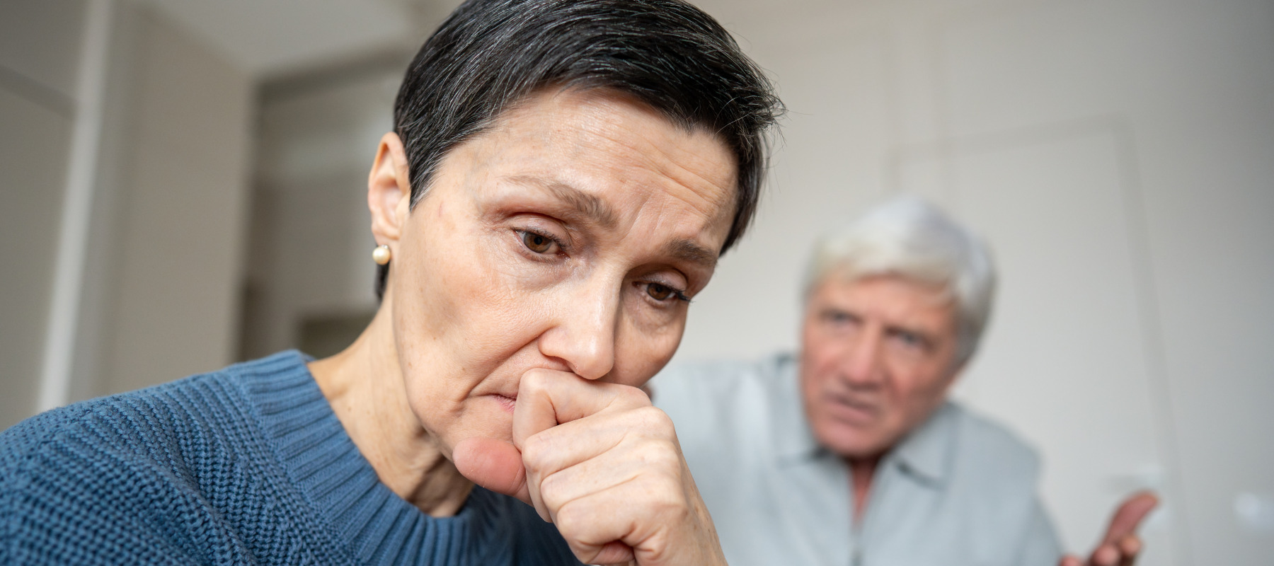 Woman looks very concerned in the foreground, while angry man behind her gesticulates.