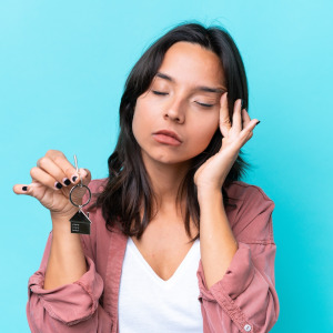 Stressed woman holding her house keys.