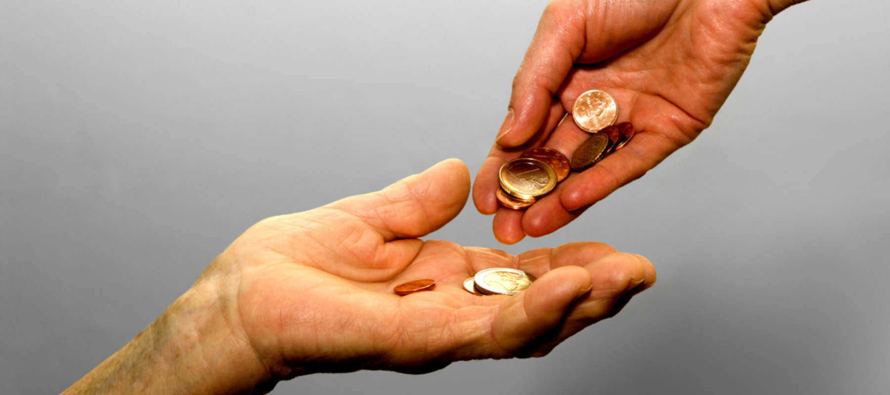 Photo of hands exchanging coins