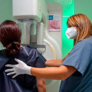 A woman gets a mammogram for breast cancer screening with the help of a nurse as part of a screening program in Spain.