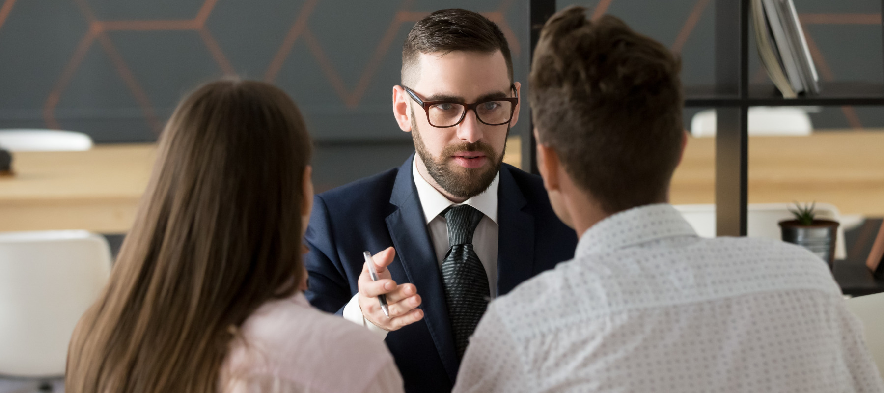 A couple sits down with a mortgage advisor to discuss a loan.