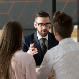 A couple sits down with a mortgage advisor to discuss a loan.