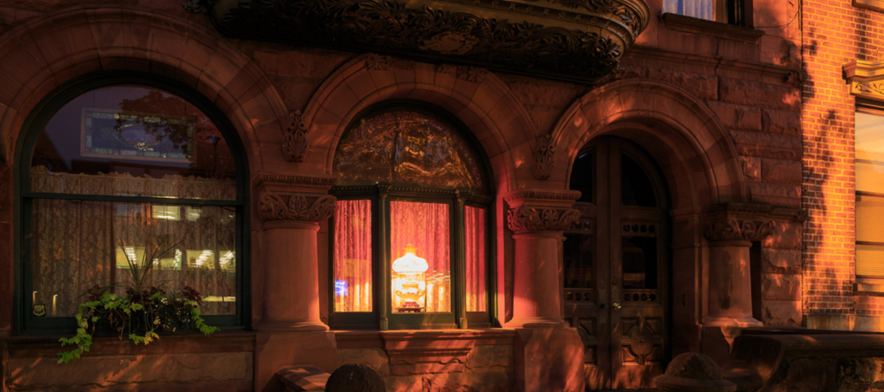 Photo of a Brooklyn brownstone with a bright light shining inside