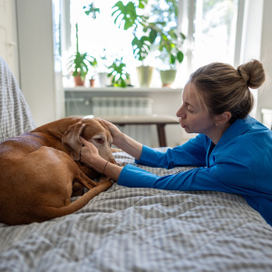 Woman sitting with her sick dog.